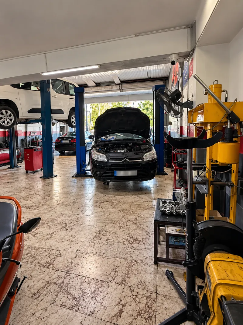 Kaputu açık araç ve mavi liftlerle atölye içi